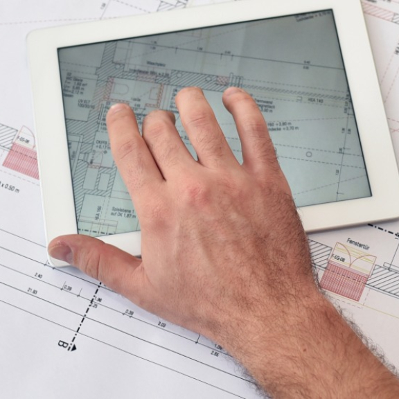 Project manager analyzing the floor plan on a tablet for a seamless site relocation.