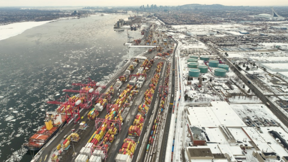Snowy Port of Montreal with a cargo ship and railway tracks for inland transport during a move to Canada with DACHSER & KOLB.