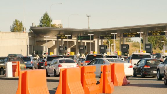 A border control checkpoint when entering Canada with digital signs reading have documents ready for customs clearance with DACHSER & KOLB.