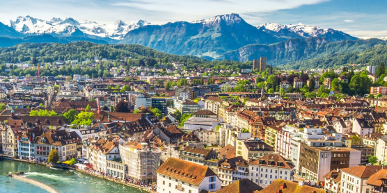 Panoramic view of the city of Lucerne with the Jesuit Church and the Swiss Alps in the background for an international move to Switzerland with DACHSER & KOLB.