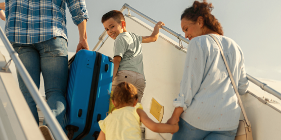 Family with children boarding an airplane – symbolic image for international moving