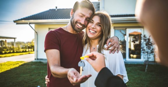 Happy couple receives house keys – relocation service for expats for home search and settling in.
