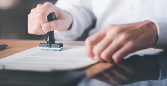 Hand stamping a document for certification, related to Relocation Service for Expats.