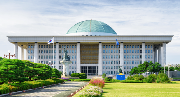 National Assembly building in Seoul with dome, landscaped grounds and South Korean flag