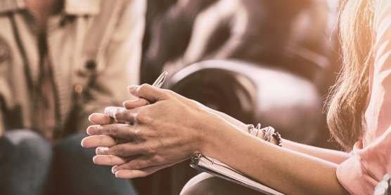 Two women talking on leather chairs – psychological counseling focused on relocation psychology.