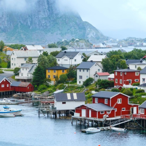 Küstenort in Norwegen mit Häusern am Wasser – Symbolbild für Anforderungen beim Umzug mit Tieren nach Norwegen.