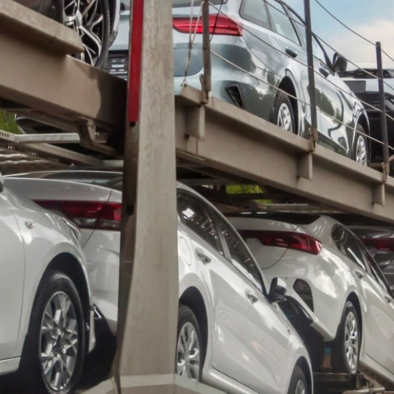 Autotransporter mit Neuwagen auf der Autobahn bei Sonnenaufgang
