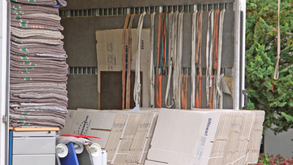 Umzugsfahrzeug mit Gurten, Decken und Kartons zur professionellen Ladungssicherung.