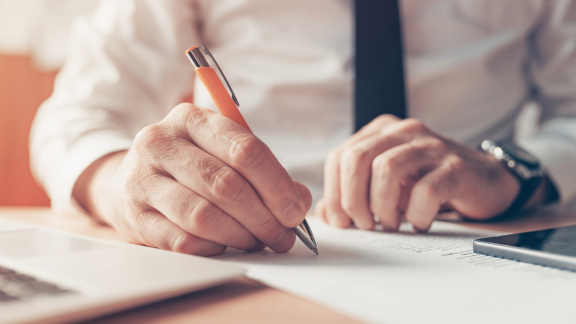 Mann trägt Informationen zur Ladungssicherung in ein Formular ein