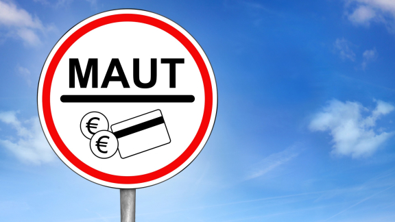 MAUT-Verkehrsschild mit Münzen und Karte vor blauem Himmel – Hinweis auf Mautgebühren