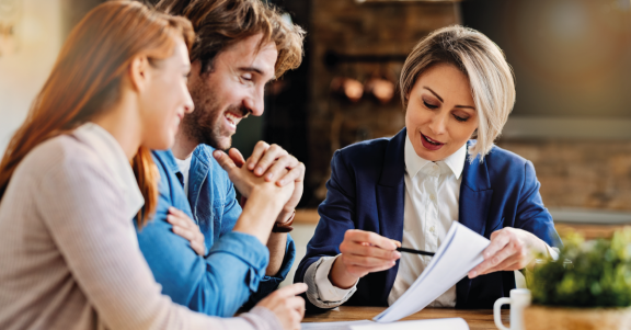 Moving consultant from DACHSER & KOLB discussing a Munich to Stuttgart relocation with a young couple at a table
