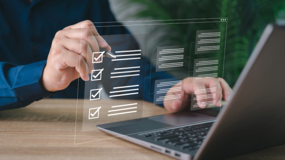 Person füllt am Laptop eine digitale Checkliste für Visum und Einreise in die EU aus.