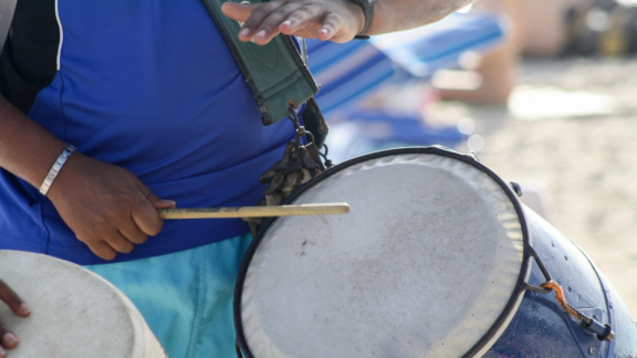 Eine Person spielt eine Candombe-Trommel