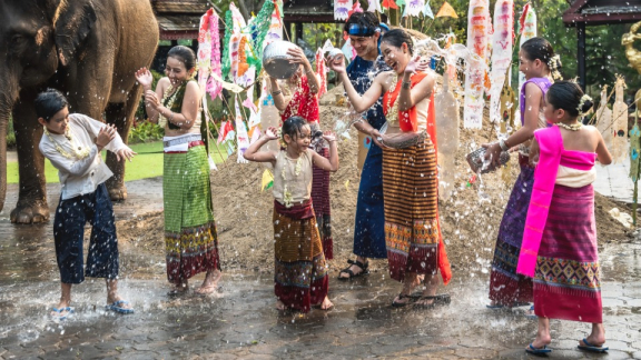 Kinder und Jugendliche bespritzen sich mit Wasser während des Songkran Festes