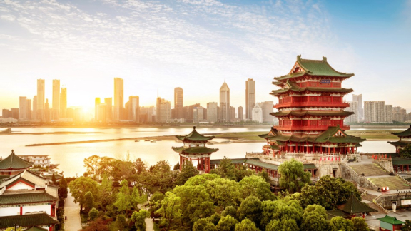 Luftbild einer historischen Stadt in China, im Hintergrund sieht man eine große, moderne Metropole